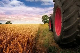 A tractor driving next to a field